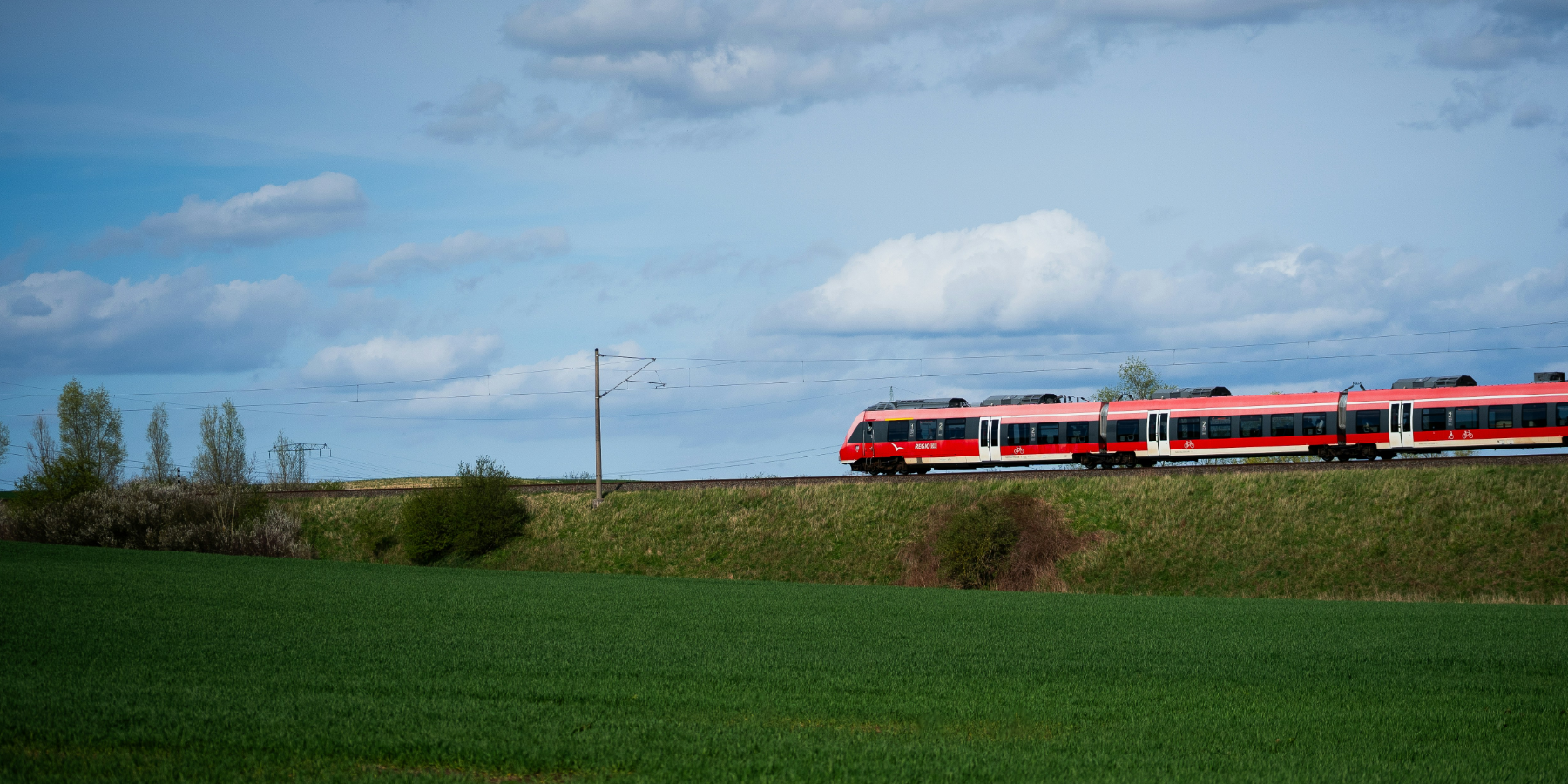 Rote Regio Bahn vor blauem Himmel